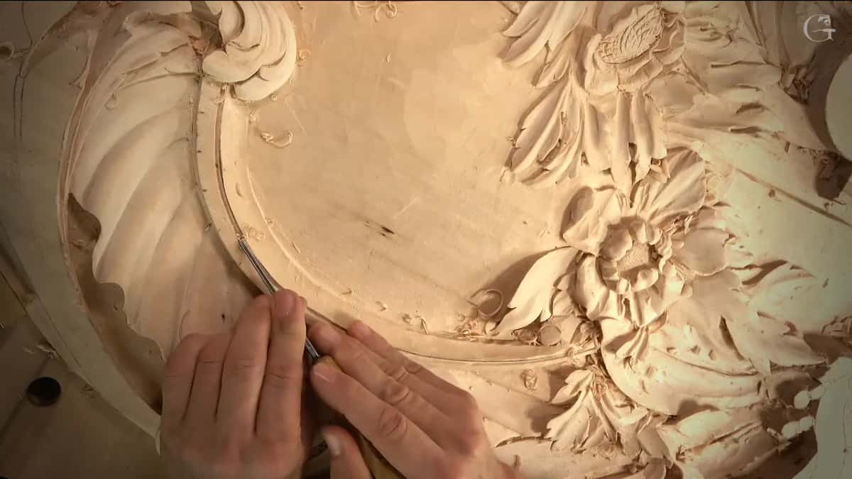 Top view of the arch groove passing a carved flower, hands low on the band