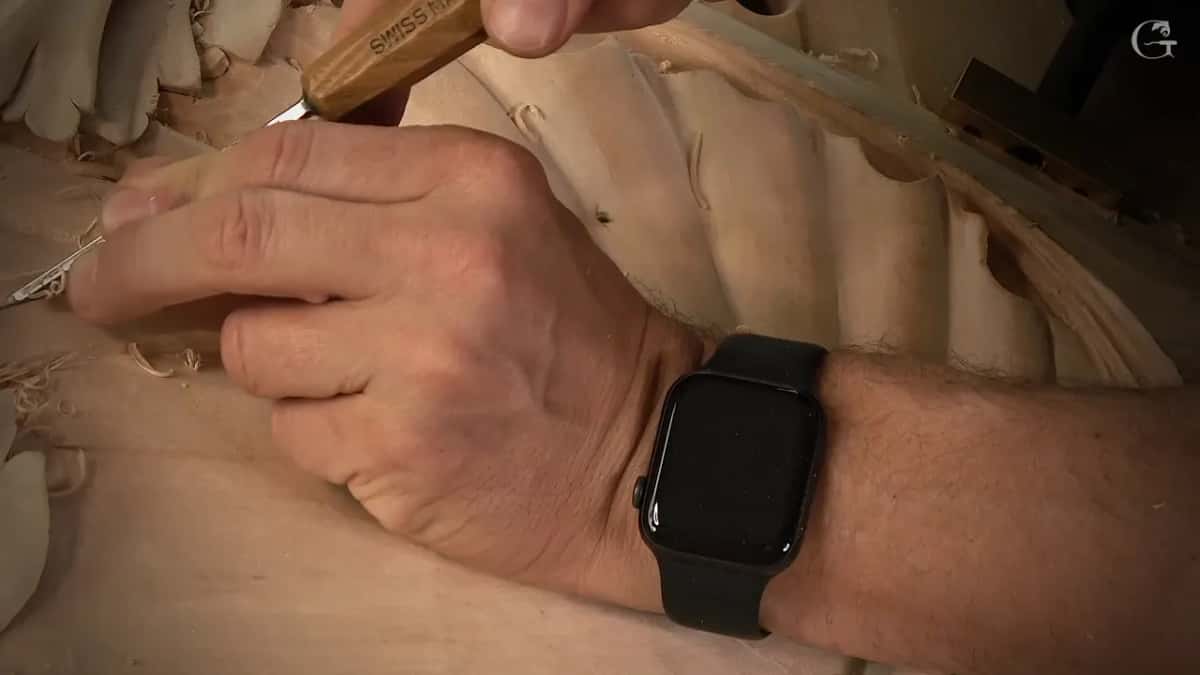Short tool in a hand with a watch on the wrist, near the shell flutes