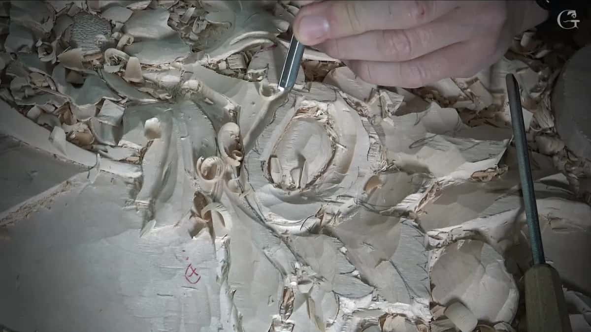 Small veiner at the flower's outer rim, a long tool lying on the board to the right
