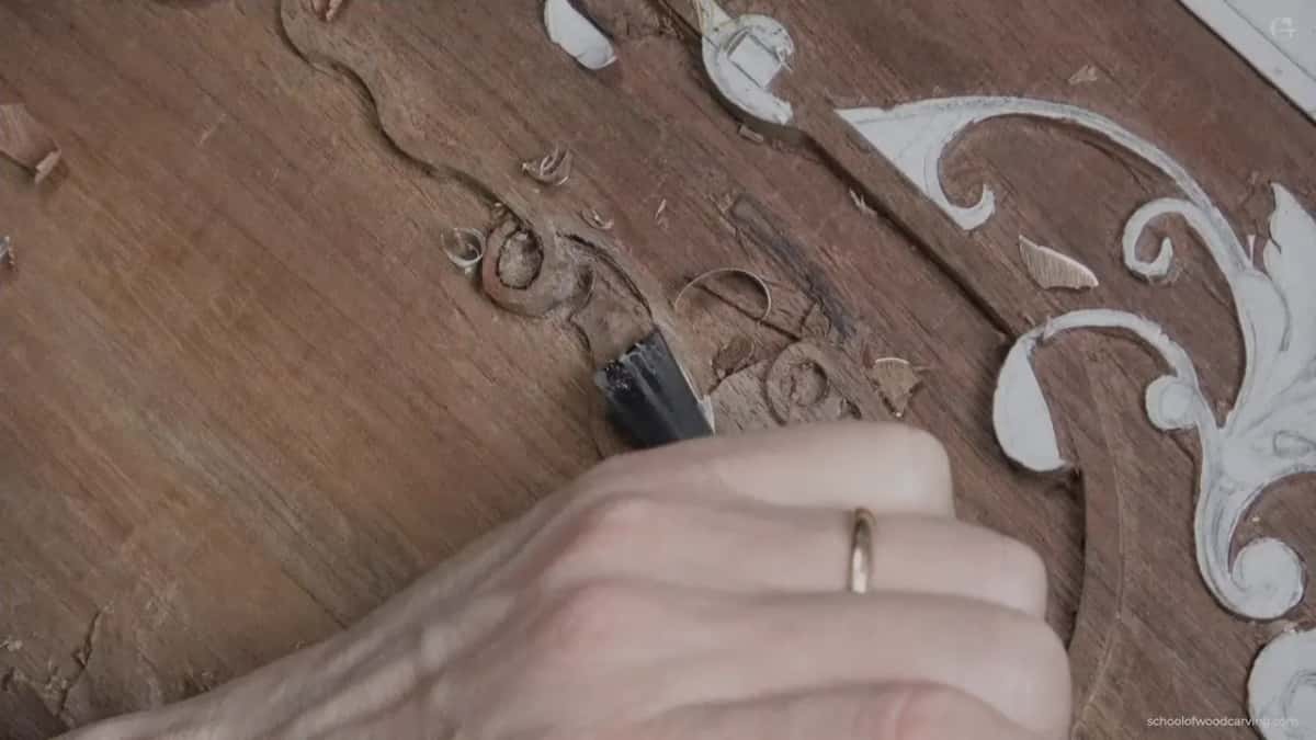 Small gouge held where two carved shapes run into one another.
