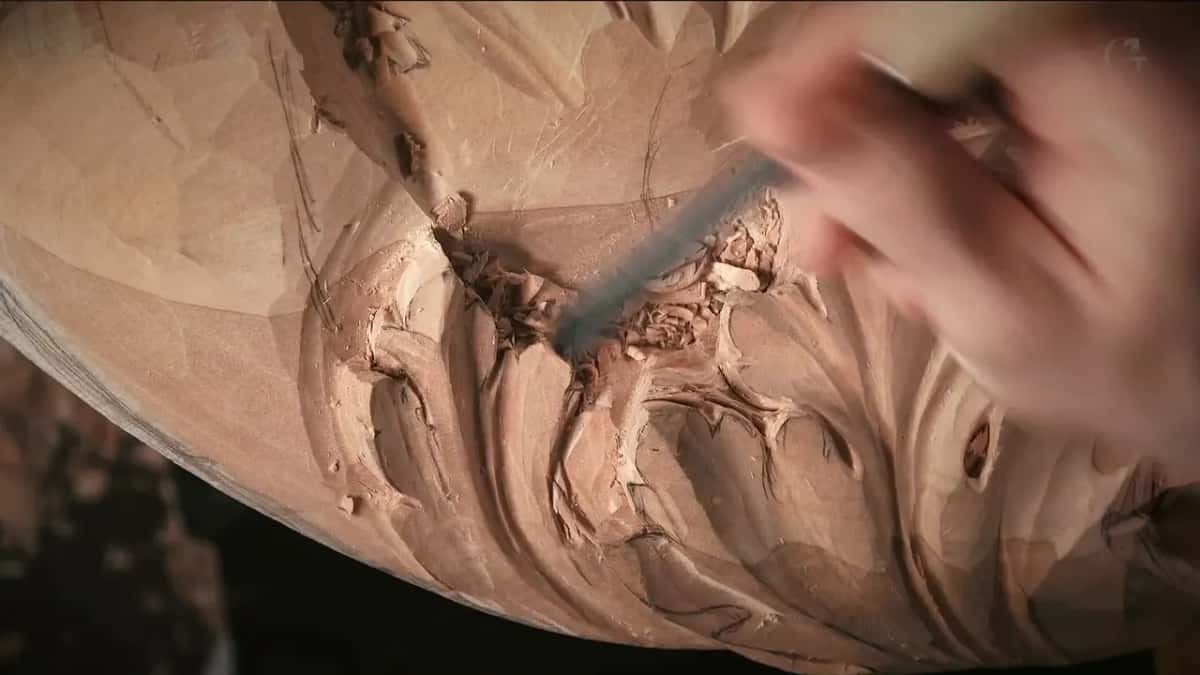 A steel shank points into crumbled chips at the middle of the leaves, with pencil lines on the facets.