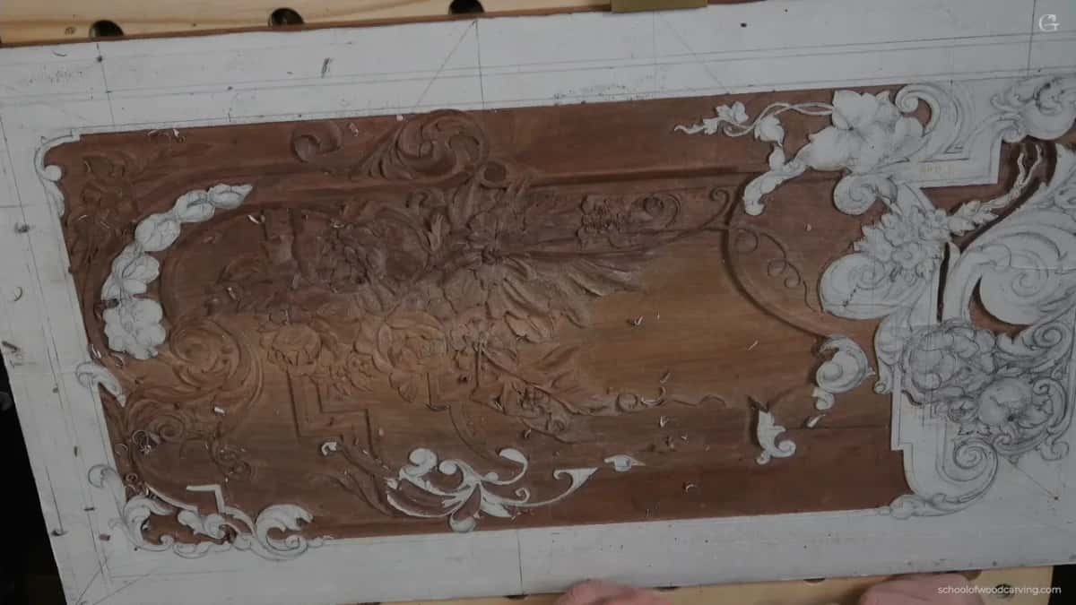 The walnut panel from above, white paper still around the outer border and on the scrolls