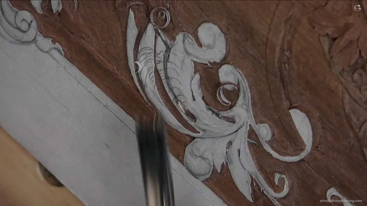 A thin curl of shaving resting on the paper scroll while the tool is only a blur below it