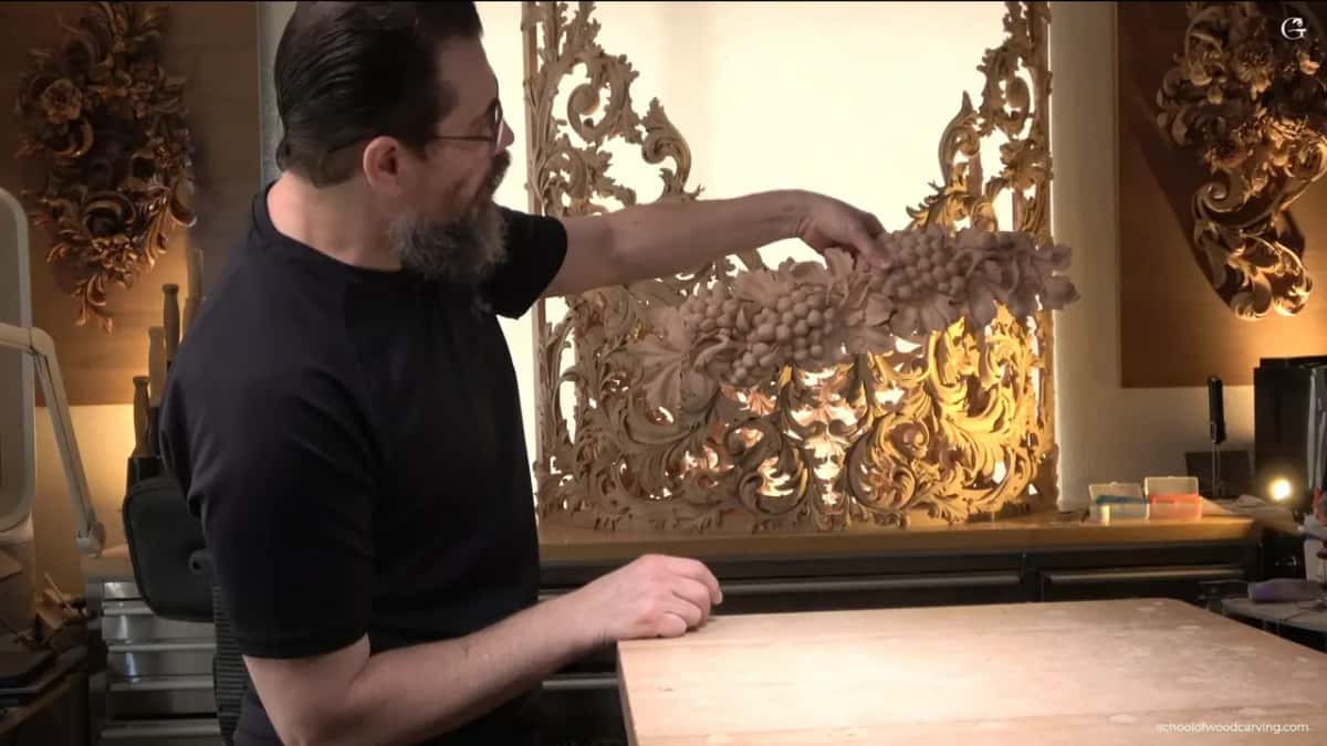 Held up in front of a tall pierced panel