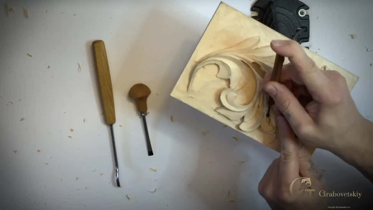 Two tools lie on the white bench beside the board, a long thin one and one with a round palm handle