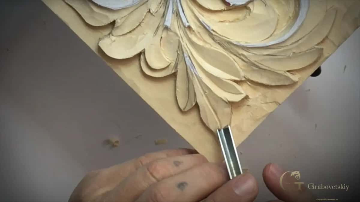 Fingers pinch a V tool by the tip of a lobe