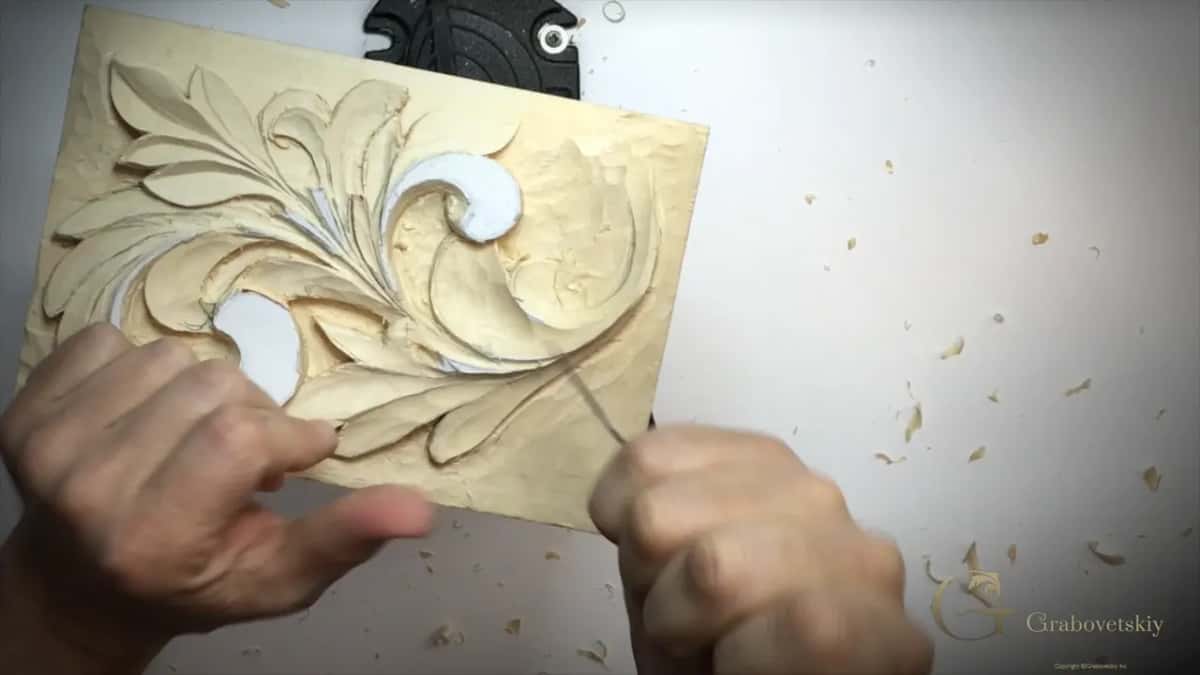 Panel tilted up by the left hand, a fine blade working a right-hand lobe
