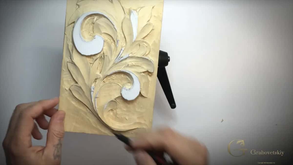 Both hands down by the foot of the upright panel, a pencil point on its lower edge