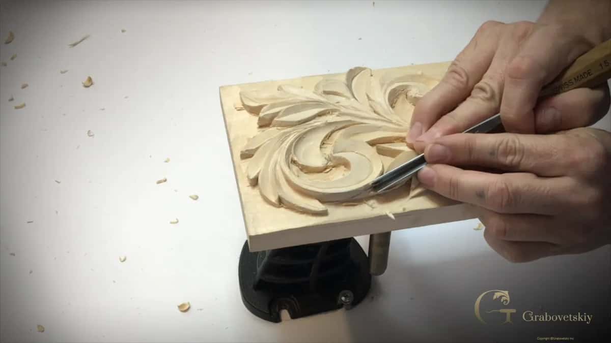 Two hands on one steel tool in the big curl, its handle printed with a number