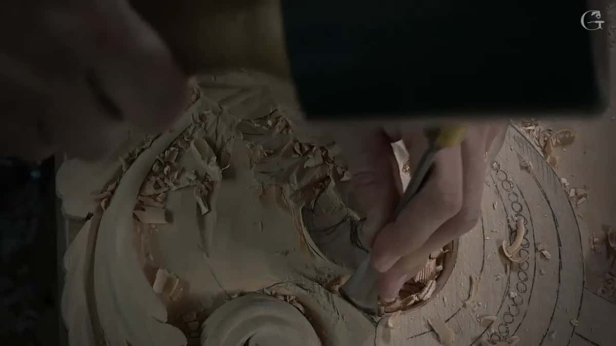 Gouge edge pushed into the hollow of the scroll with shavings piled up around it
