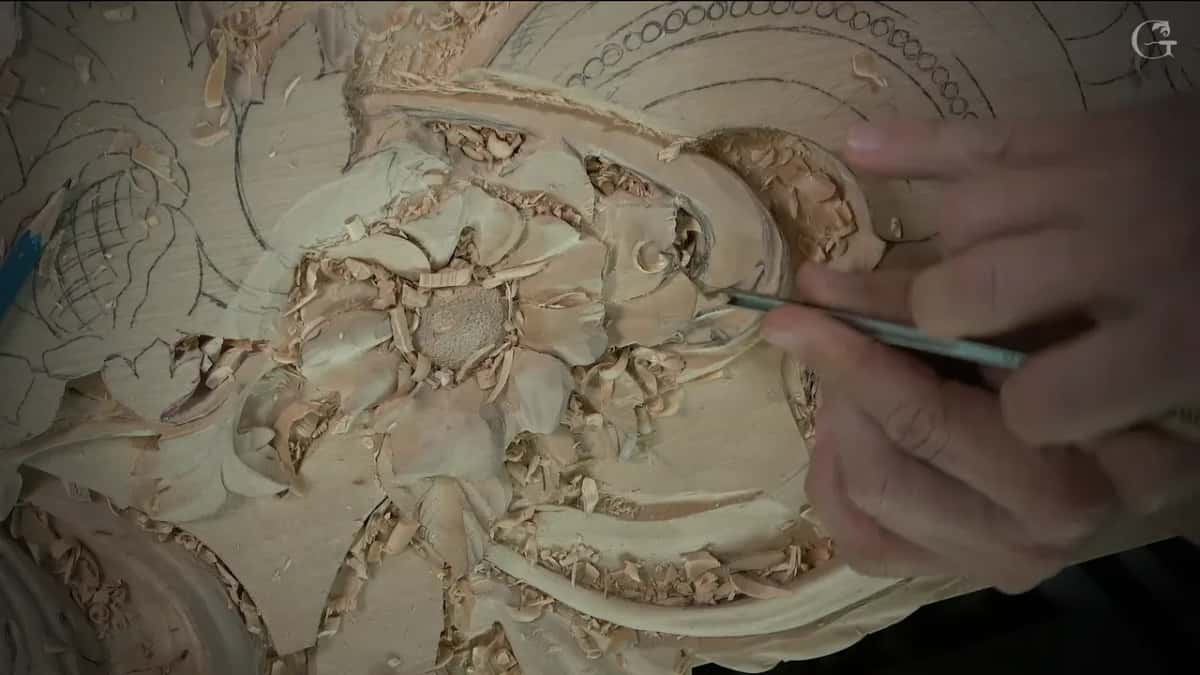 A long thin veiner at the tip of the scroll curl, held between both hands