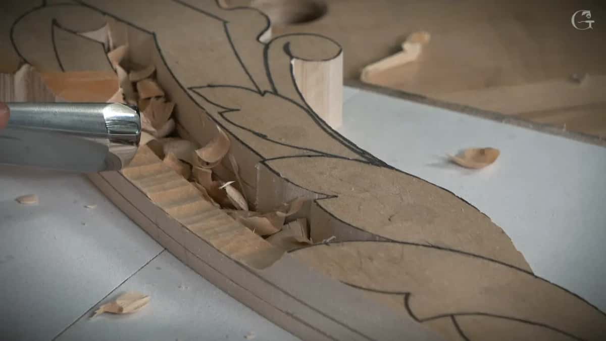 Short ridges left by the chops, chips heaped in the channel and a bright ferrule at the left