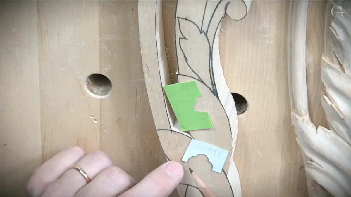 Two little paper profiles, one green and one pale blue, laid against the pencil outline