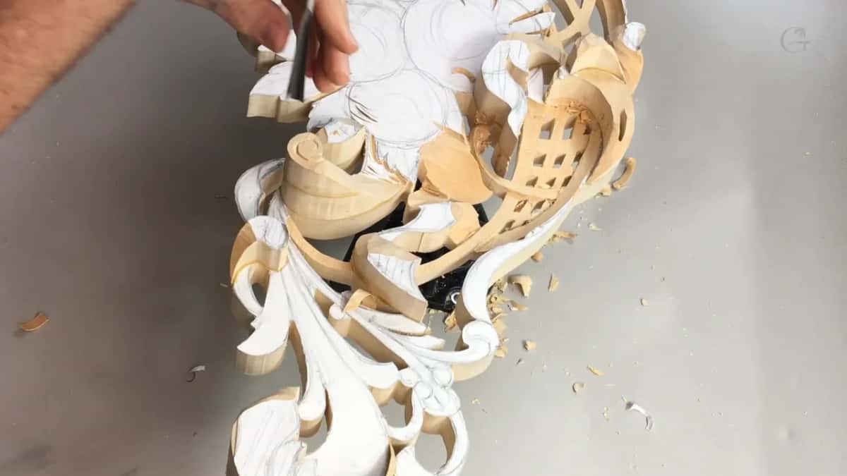 Scroll and lattice up close, with a tool held upright above them