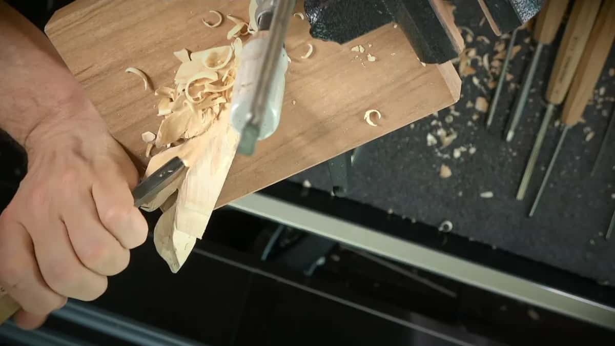 Shavings pile up while a long clamp holds the stem