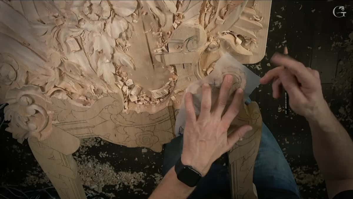 A clear sheet with the drawing held flat over the area, a marker in the other hand