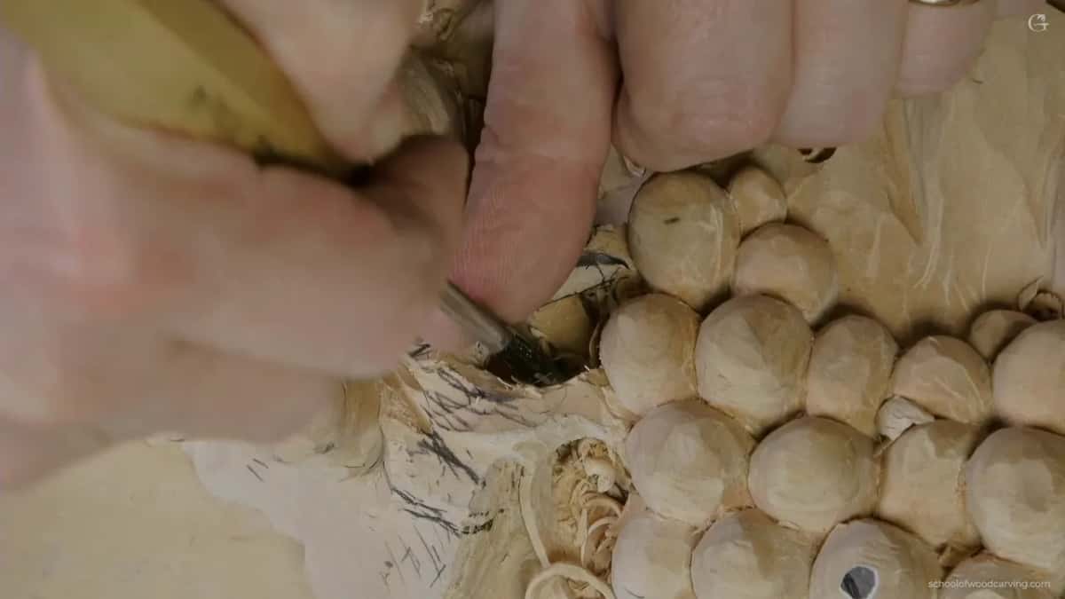 Two hands on a pale-handled gouge
