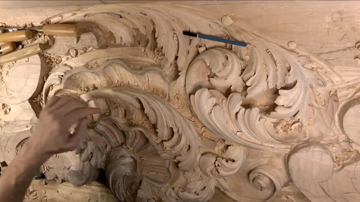Wider view of the board, one hand reaching in among the scrolls.