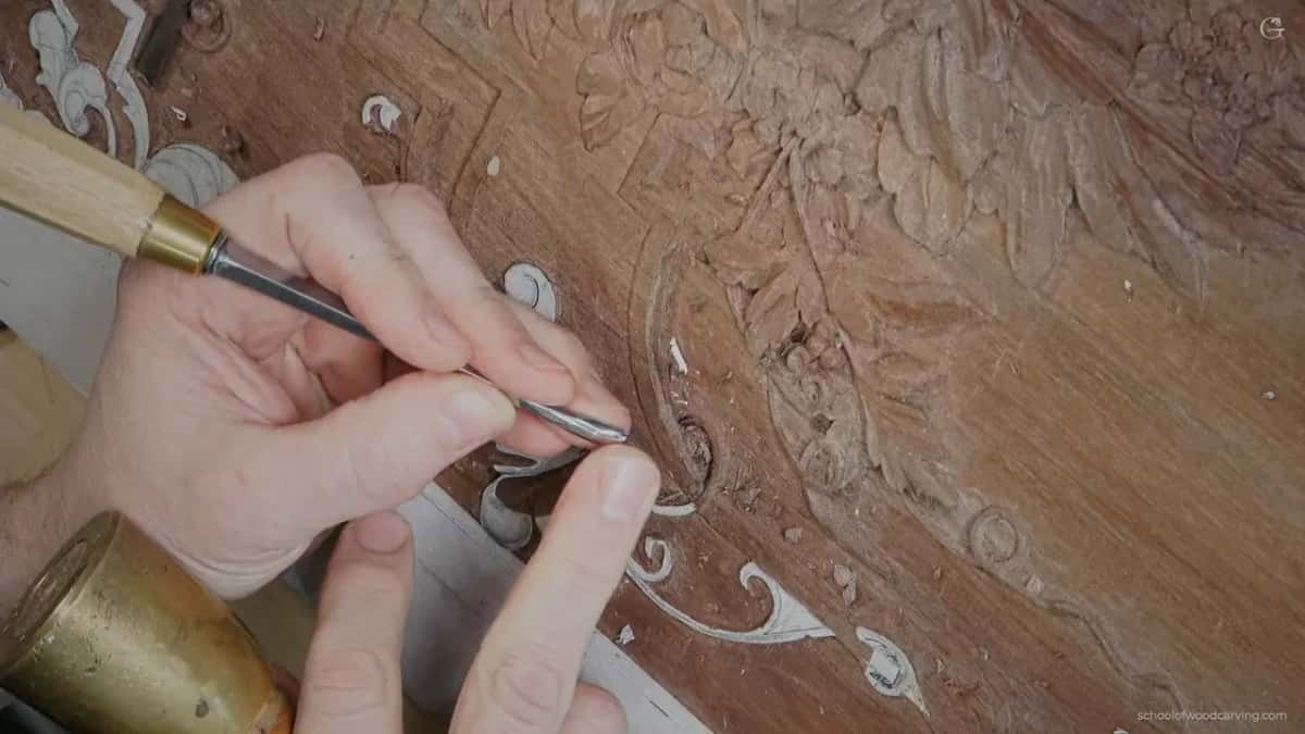 Light handle with a brass ferrule, left fingertips steadying the blade and a bronze mallet head below