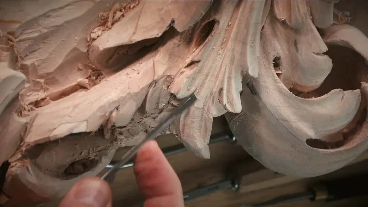 Two fingers holding a thin tool into the hole