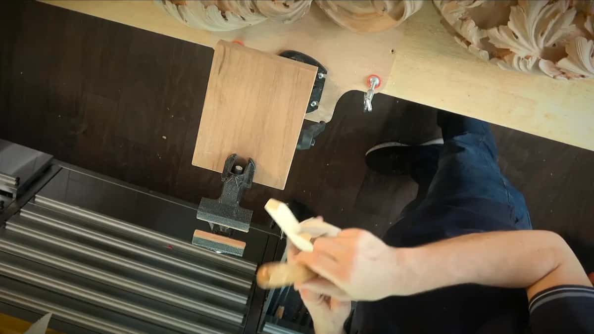 Paring a corner off the handle with a straight blade, the piece held in hand