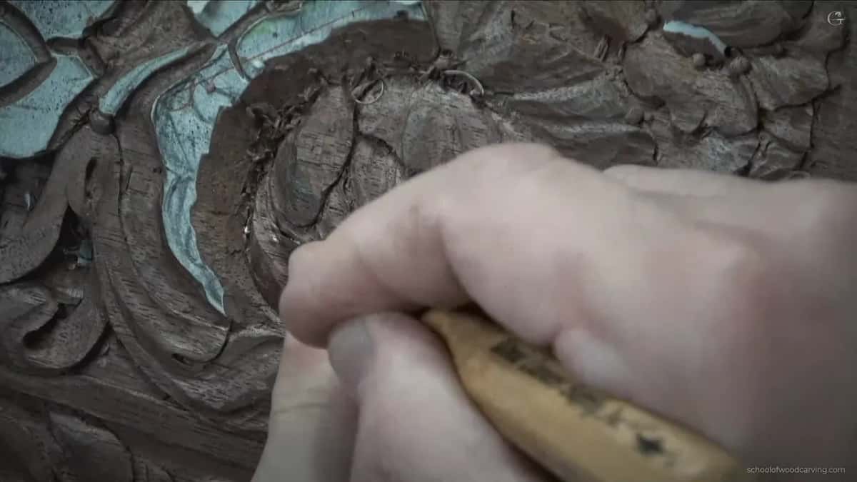 Pale wood handle gripped in a fist above the flower