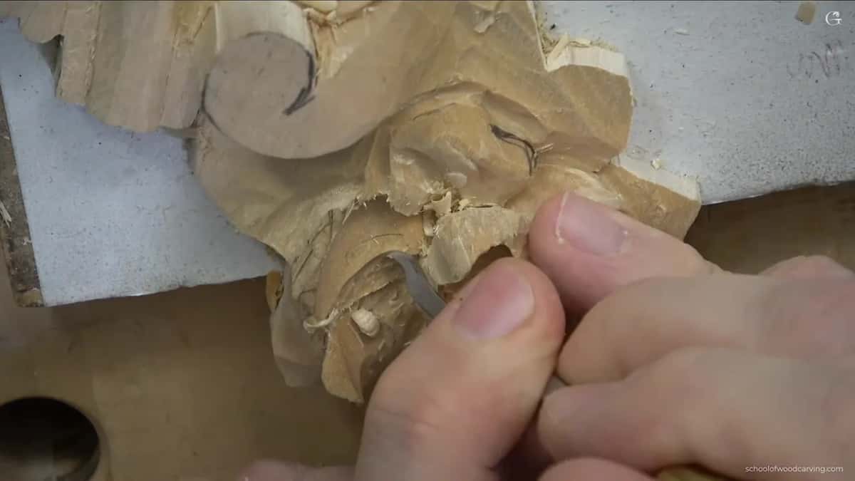 Small blade held in the fingertips by the edge of the flower, shavings stuck around it.
