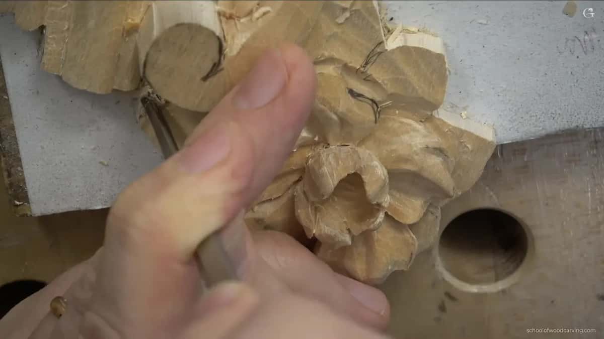 Big thumb across the front of the shot while a gouge works by the scroll.