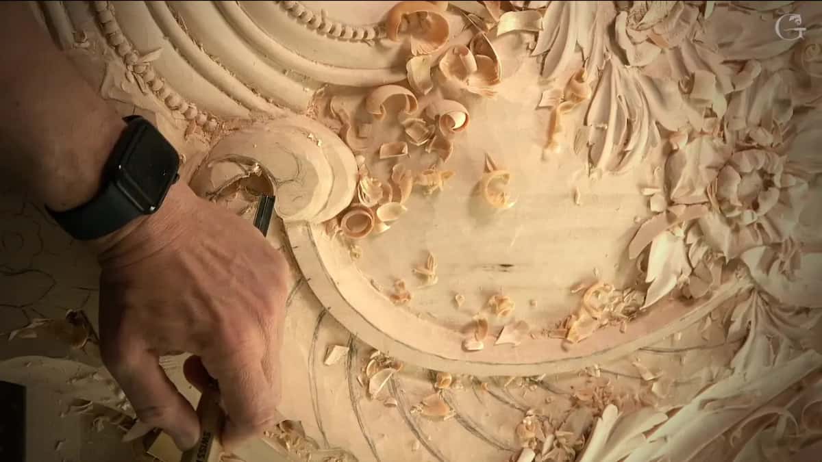 One hand and a small tool at the scroll