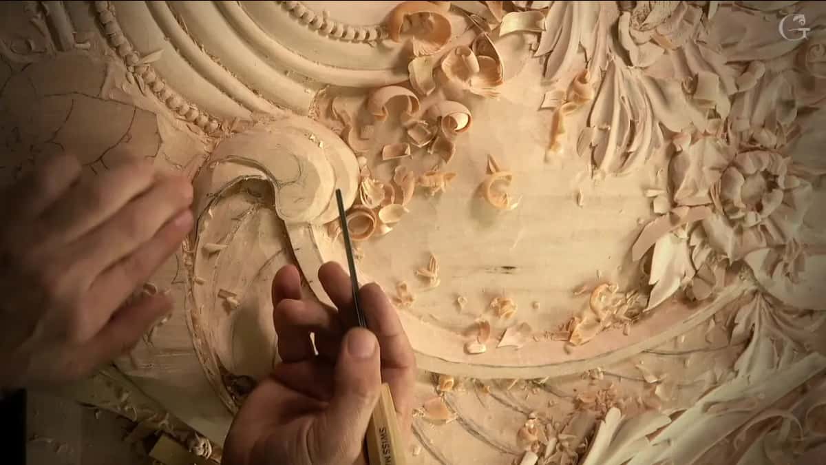 Thin tool held upright over the scroll
