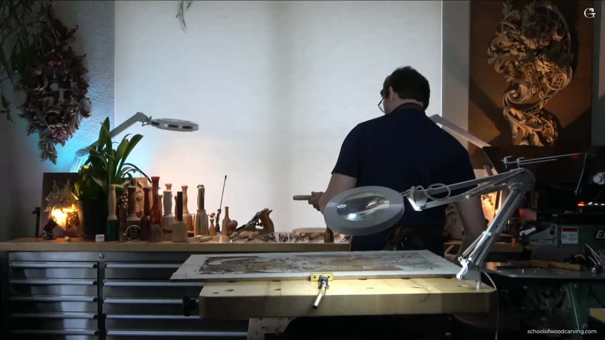 Studio from behind, the panel lit on the bench and him standing at the back counter