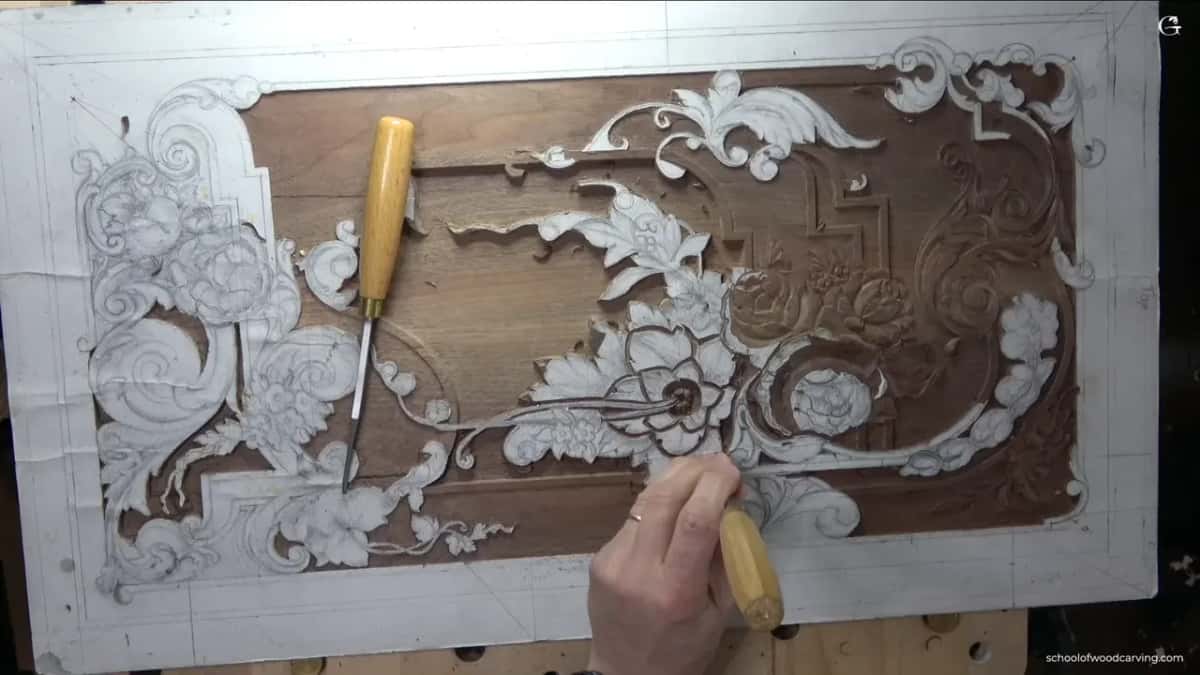Whole panel from above, paper pattern still on, one pale handled gouge in his hand and one lying on the left