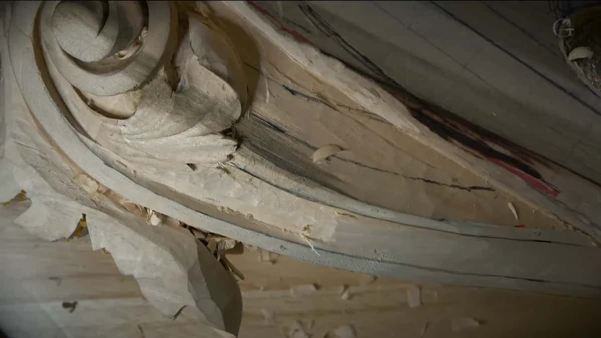 Close view of the scroll with pencil lines and red marks along the side still to carve