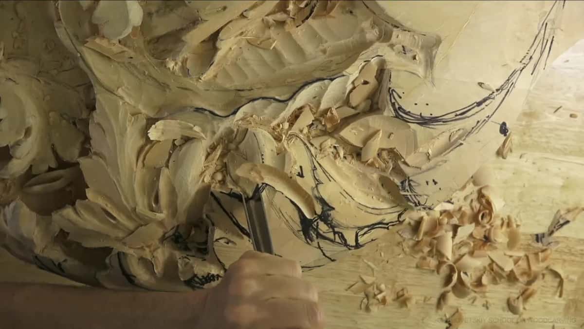 Chips pile up on the bench while a straight gouge chops into the outline.
