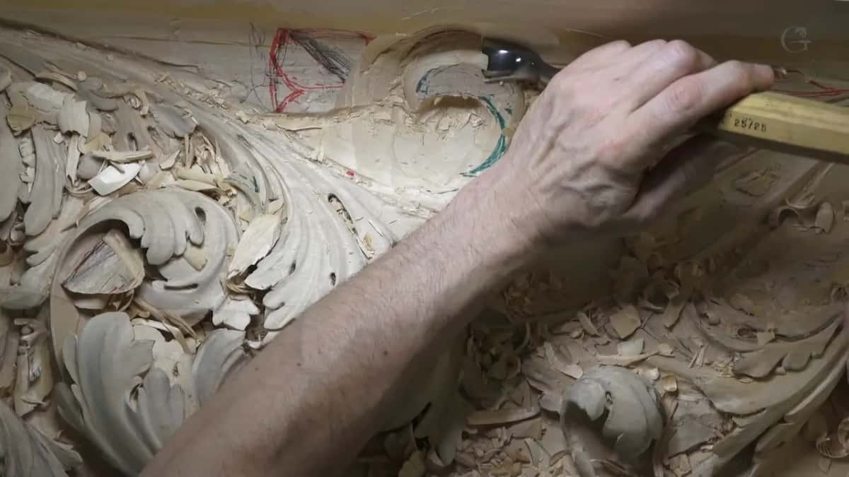 Close under the flat band, a yellow handle lies almost level with it while the blade works the curve.