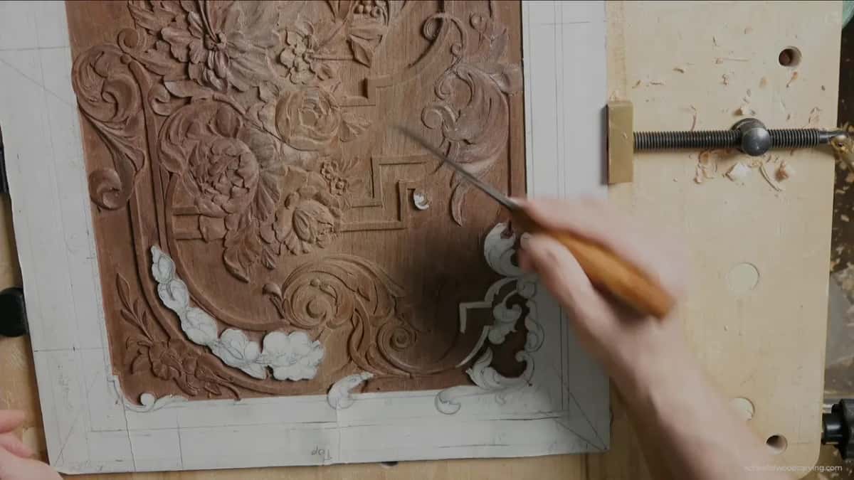 From above, a gouge in the right hand points toward the middle of the carved panel
