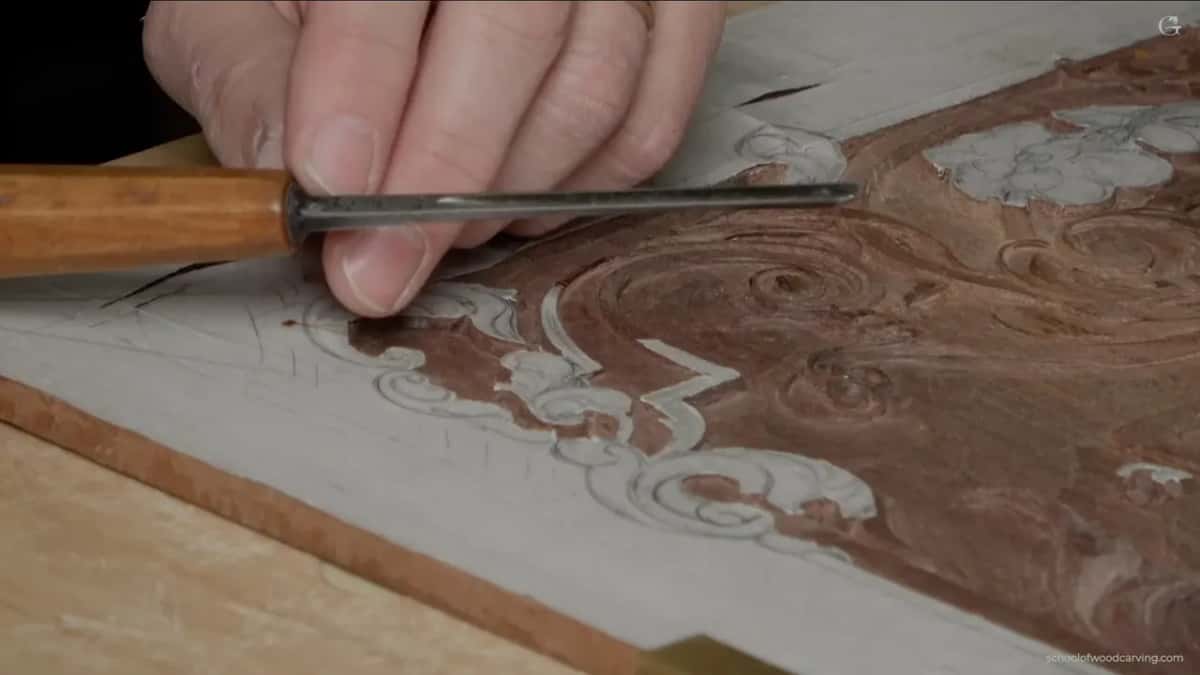 Thin veiner with a pale handle, its edge resting in the groove along the paper border