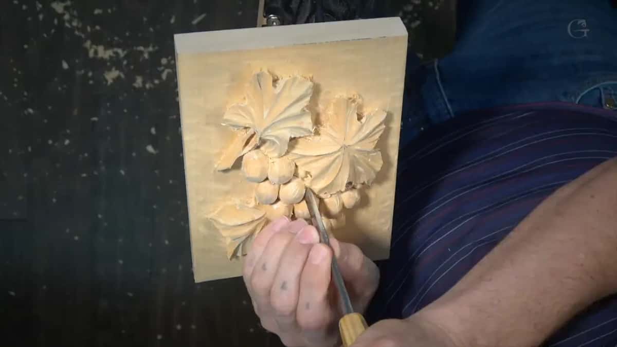 Panel held up in one hand, a gouge at the lower left leaf