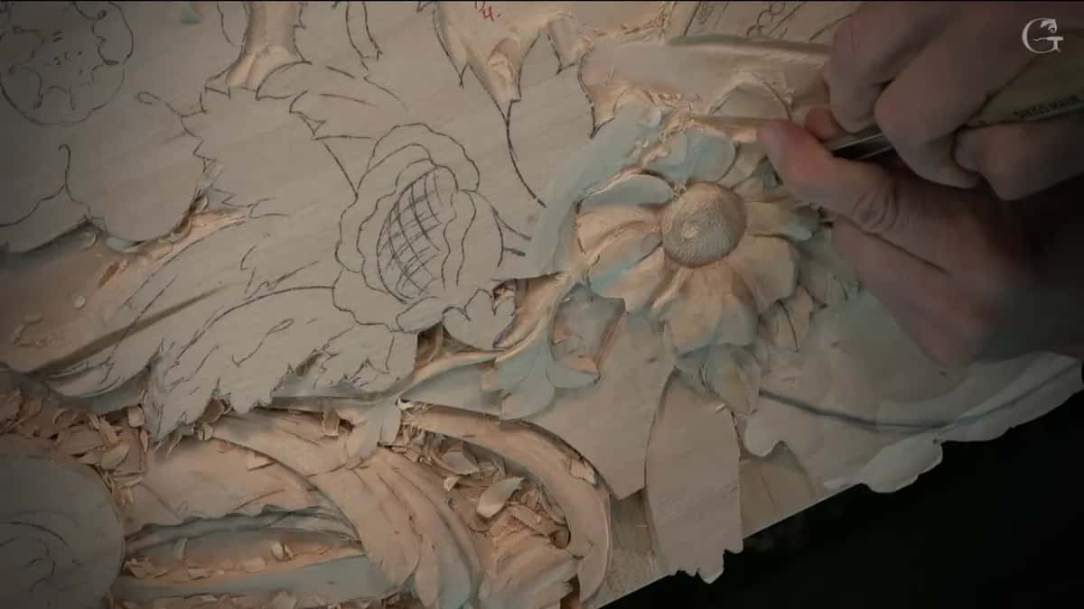 Fingers steering a slim gouge into a petal