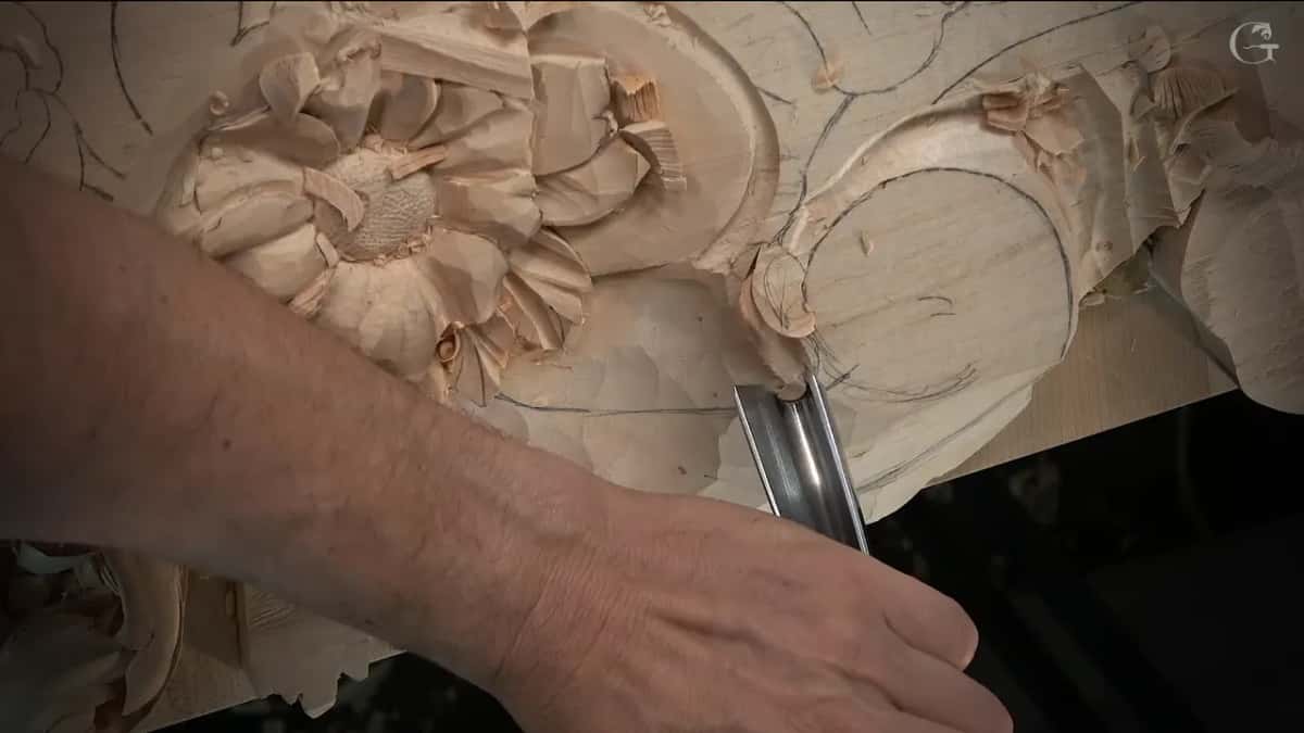 Wide gouge set straight down at the round scroll, flower to the left