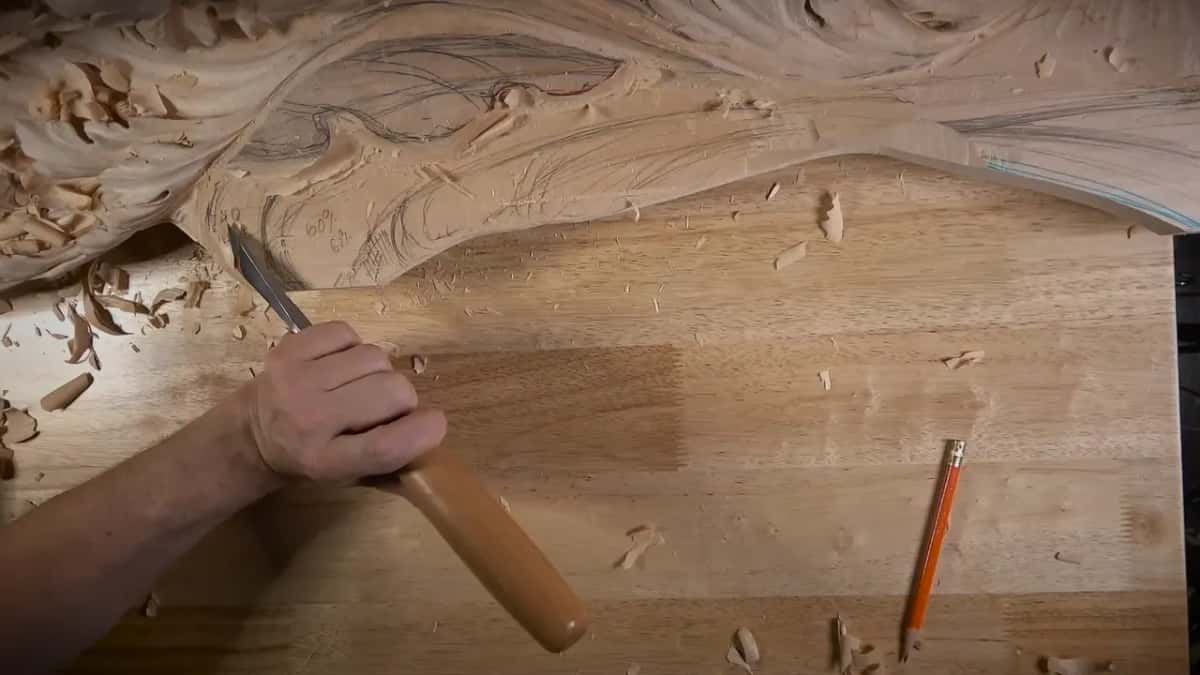 A skew chisel waits at the lower edge of the slope, pencil lying nearby