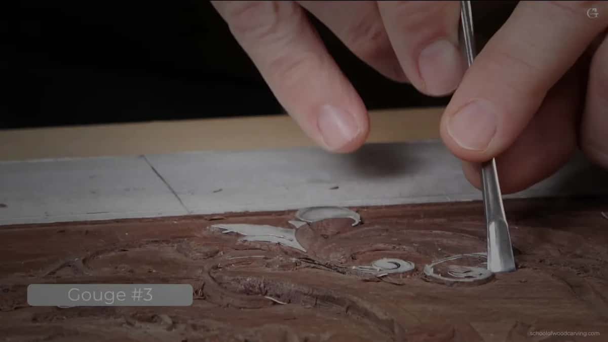Bench-level shot with the Gouge #3 card, the tool standing upright in a scroll