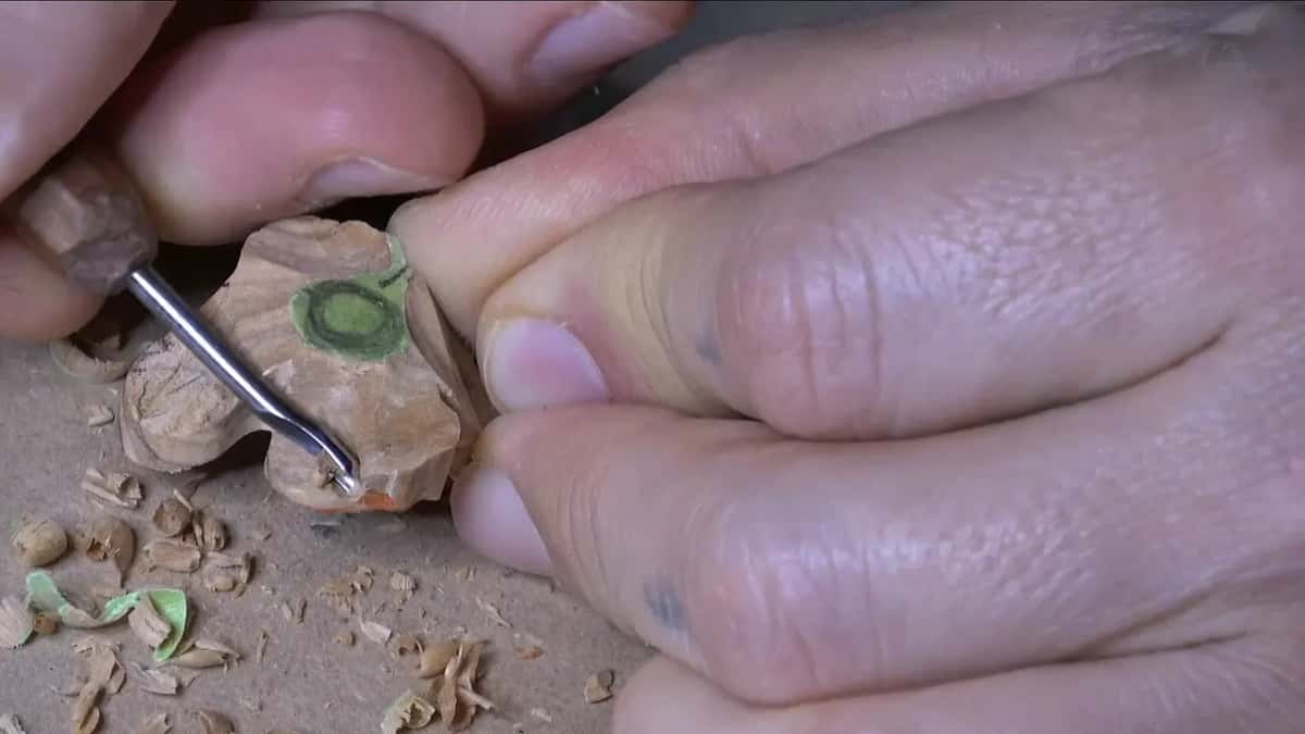 Small gouge sinking a hollow at the edge of the second flower, whose center is still marked in green