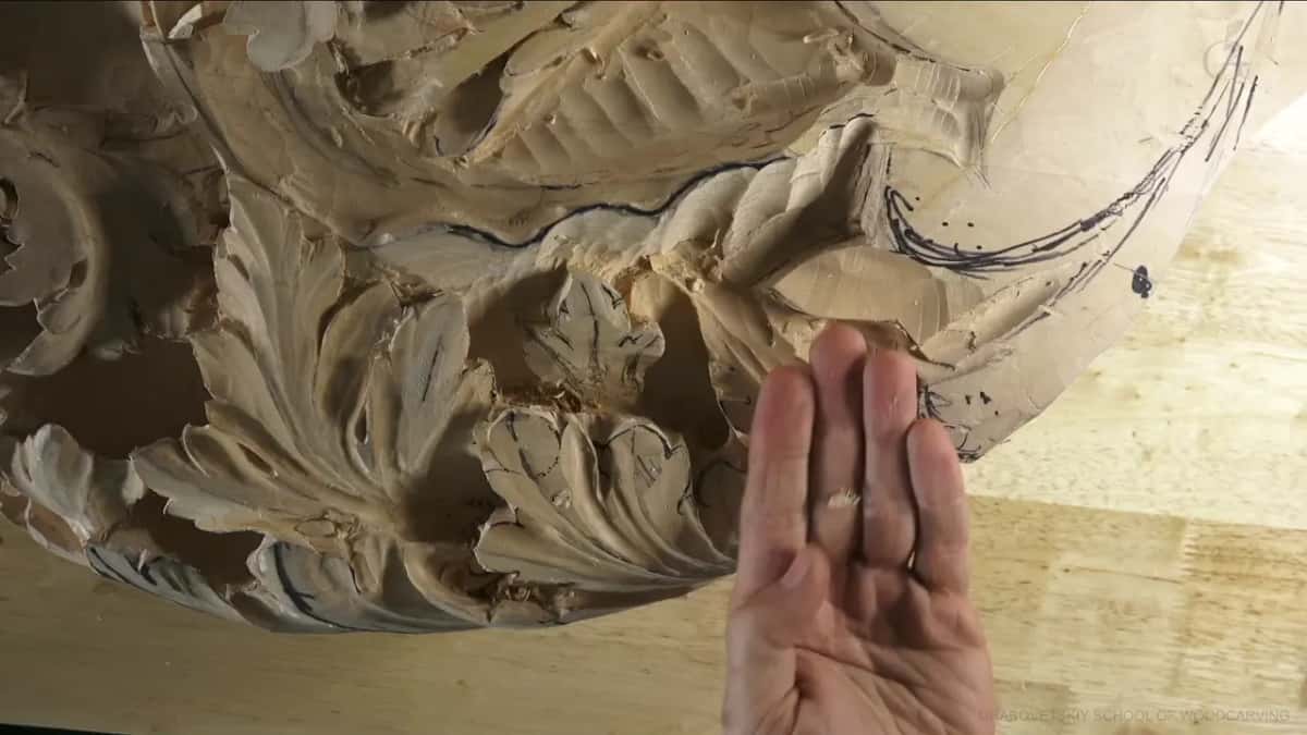 A tiny plug of wood rests on the fingers of an open hand held up to the camera.
