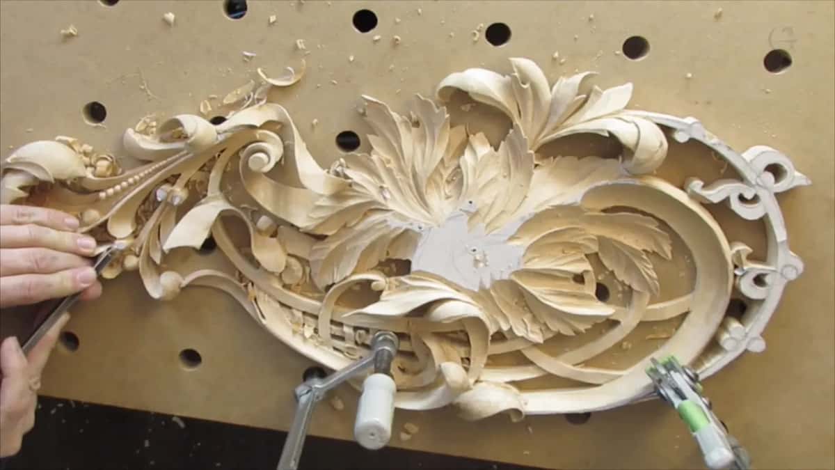 Whole oval panel clamped on the bench board, openings pierced under the leaves