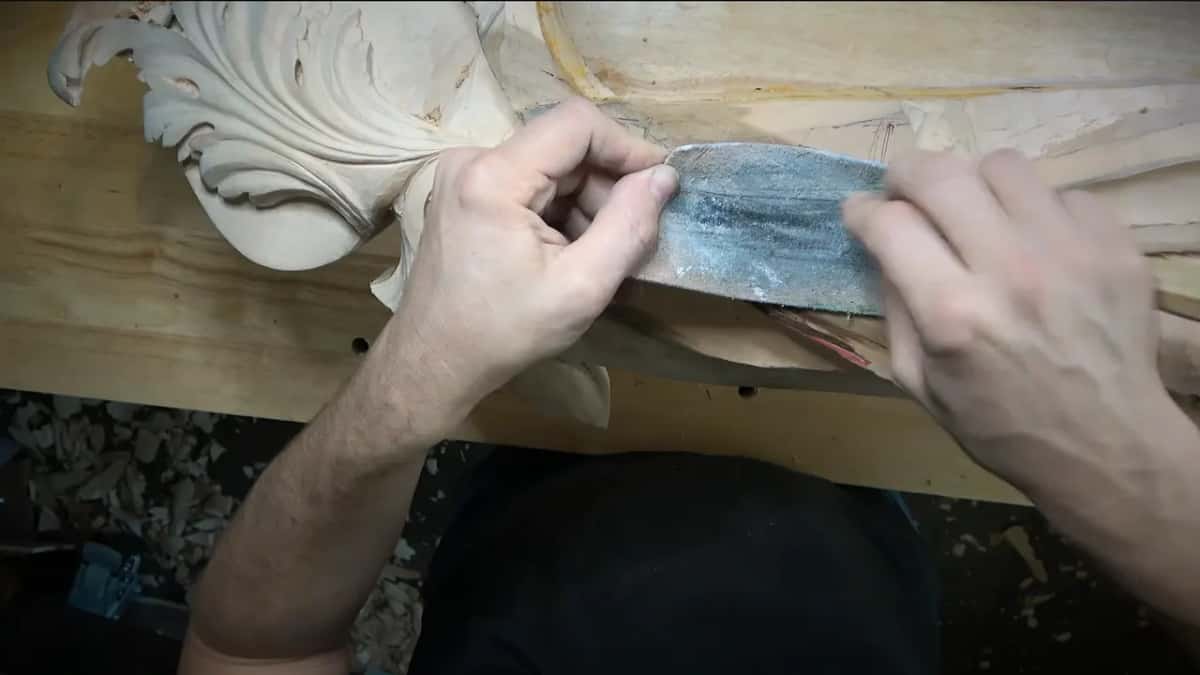 Leather laid right across the carving while a tool is drawn over it, the drawn leaf lines underneath