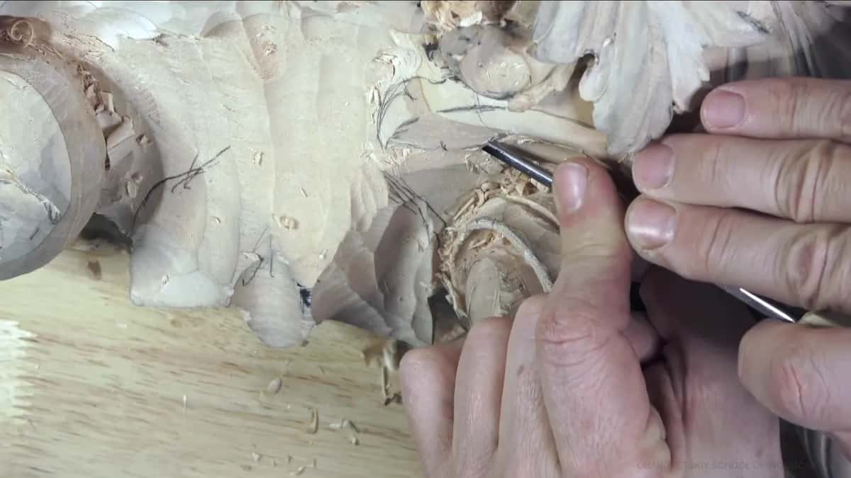 A thin blade goes into a leaf right next to a rounded form, with pencil lines still showing.