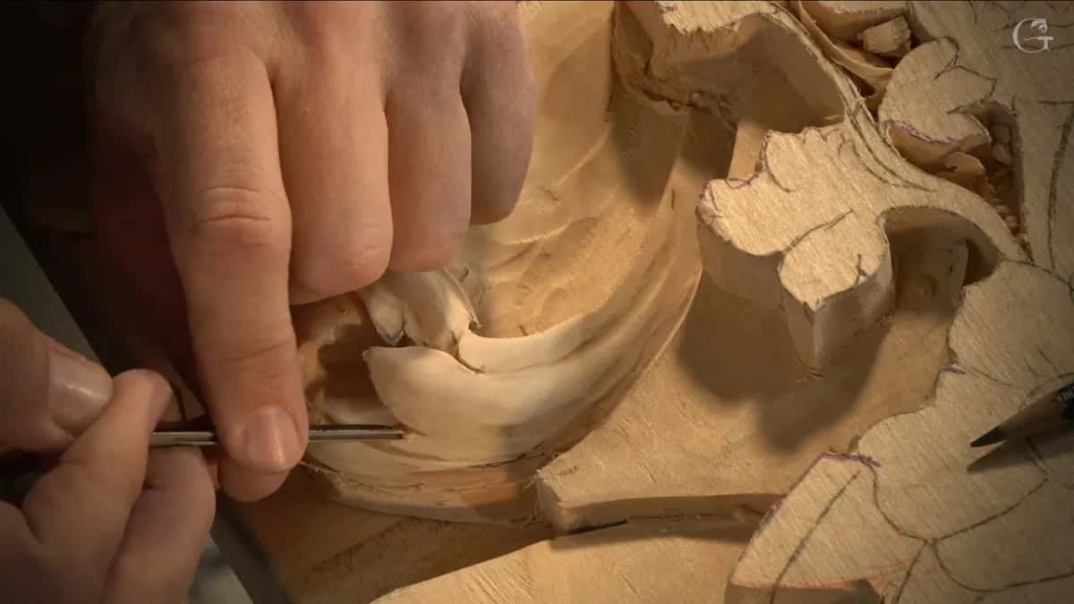 Pencil left on the uncarved board, a thin veiner works under a lobed edge.