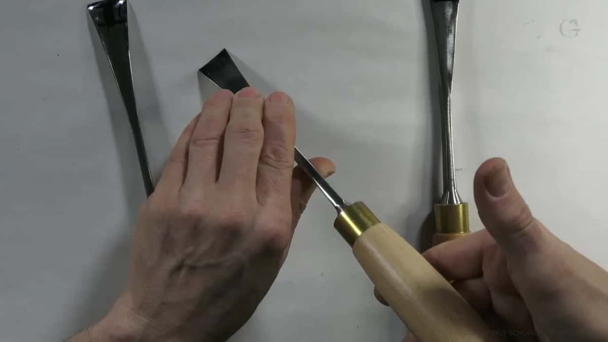 Picked up by its handle, a single gouge between two others