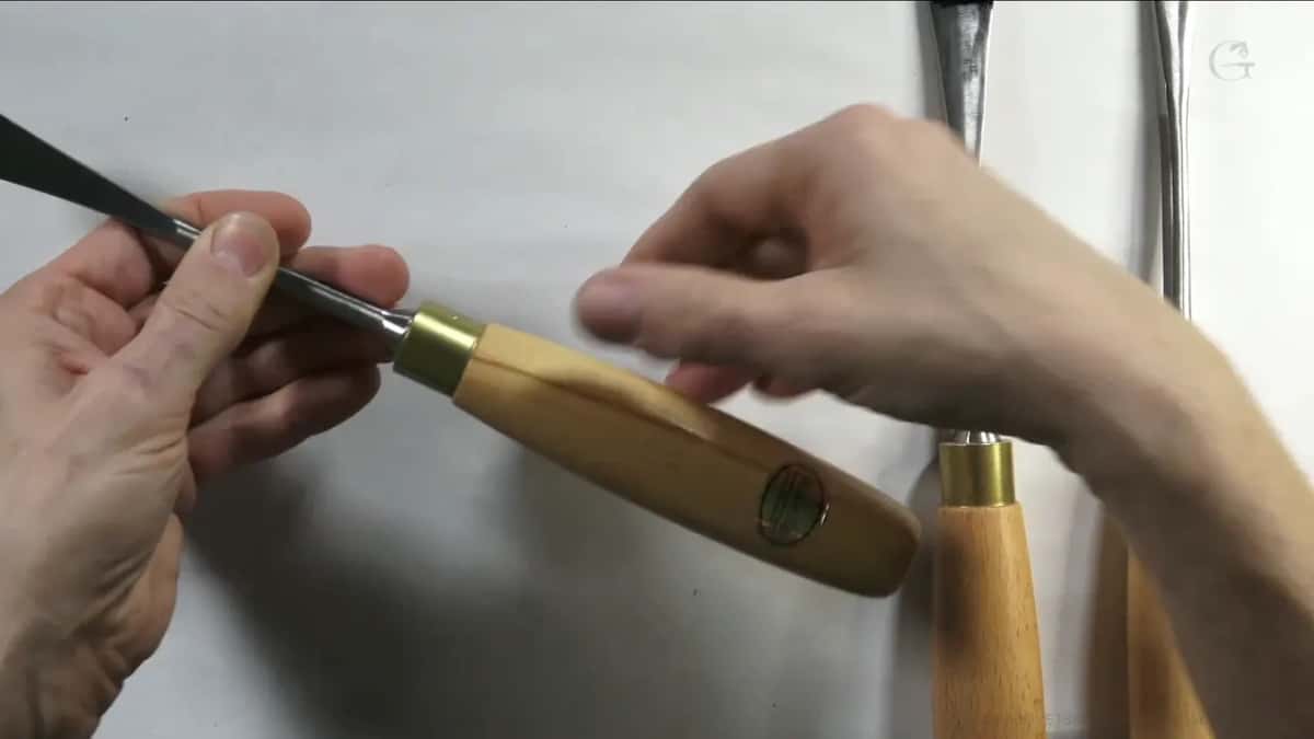 Gouge held at a slant in one hand